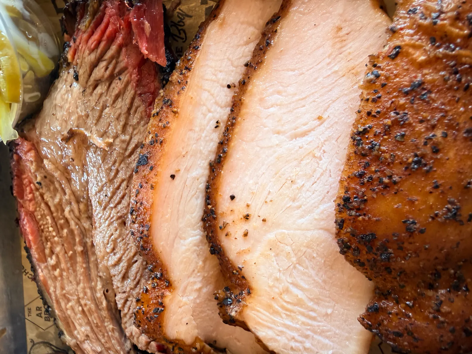 Close-up of Wright's fatty brisket slices next to peppered smoked turkey at the Benton location