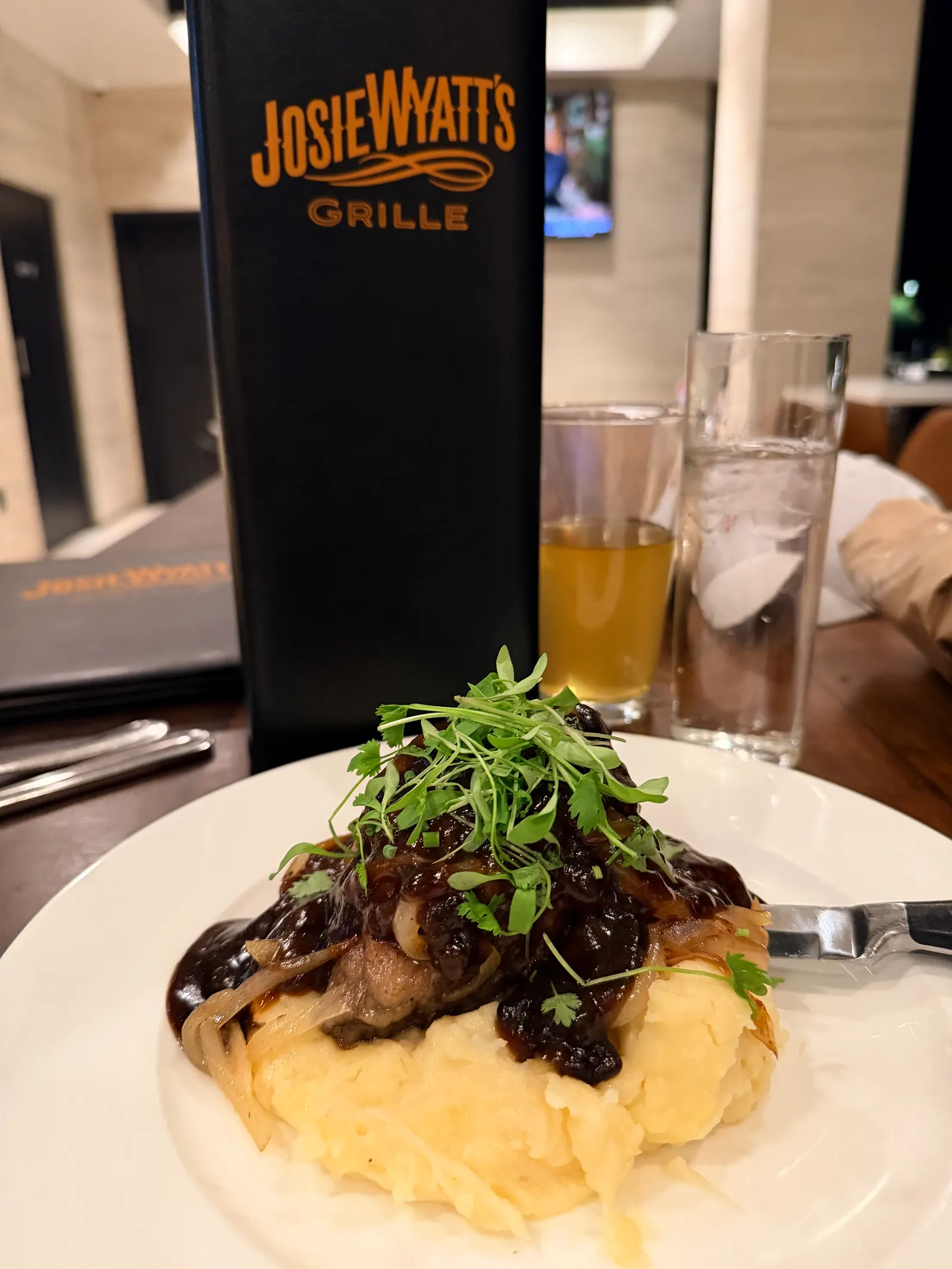 Steak over mashed potatoes with onions and microgreens at Josie Wyatt's Grille inside Hoodoo Moab