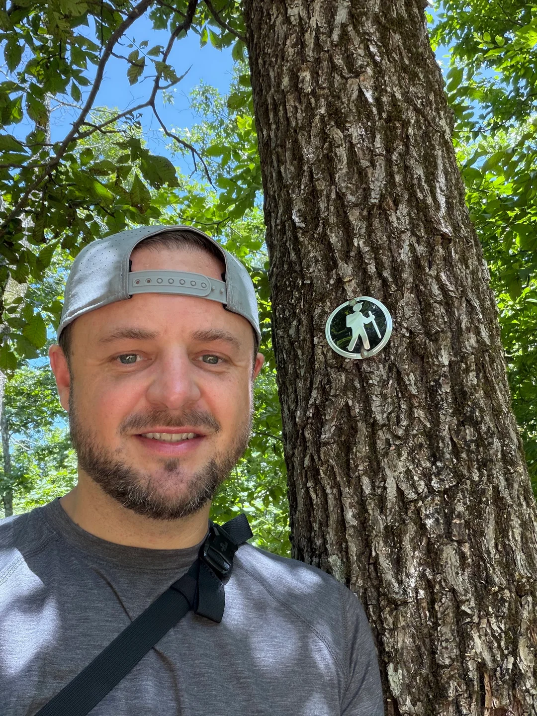 Brison McPhail on the trail to Signal Hill on Mount Magazine, next to a hiker trail marker