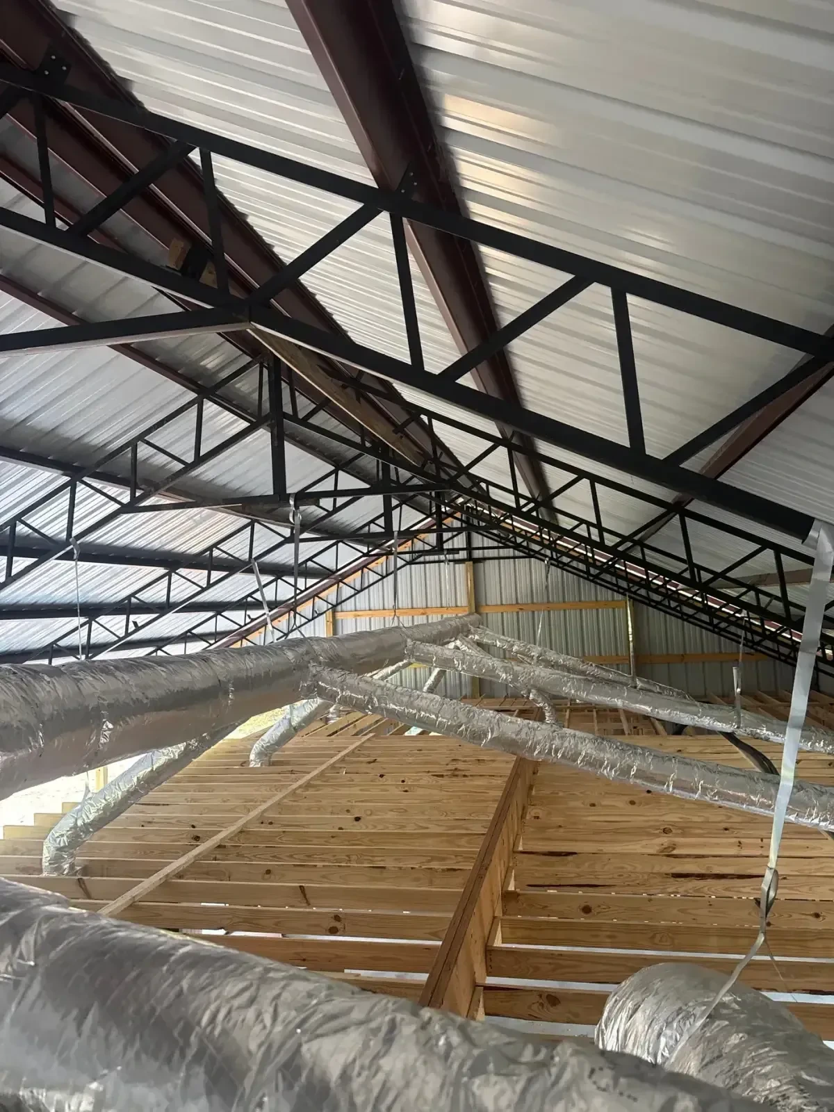 Insulated supply duct runs strapped along the steel framing of a new metal building, installed by Jet Heat and Air in West Little Rock, Arkansas