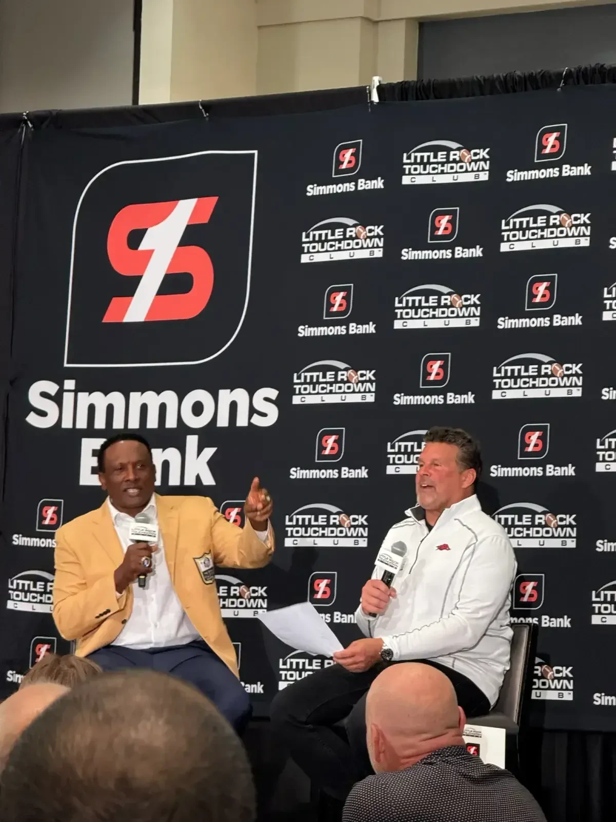 Tim Brown in his gold Hall of Fame jacket on stage at the Little Rock Touchdown Club