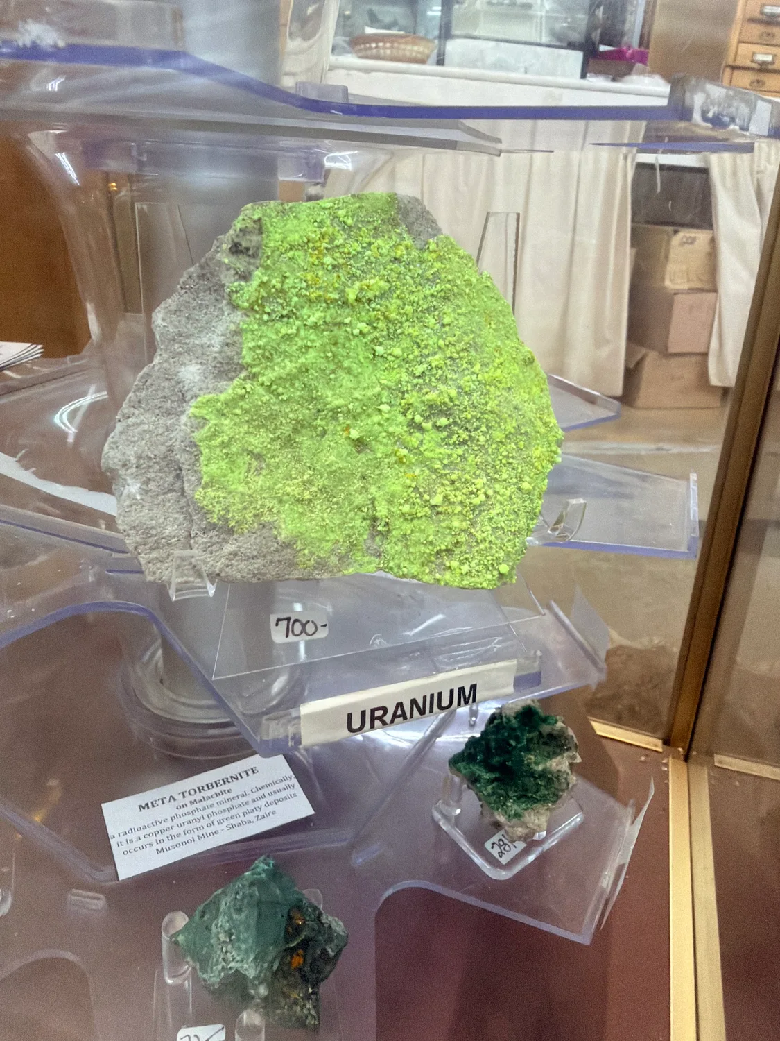 Bright green meta-torbernite uranium mineral specimen with a price tag